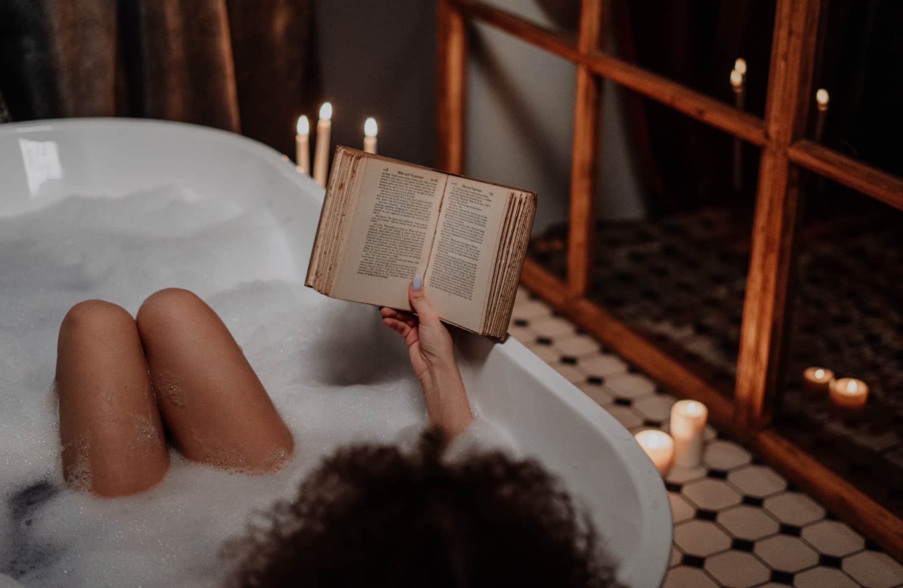 дівчина читає книжку у ванні